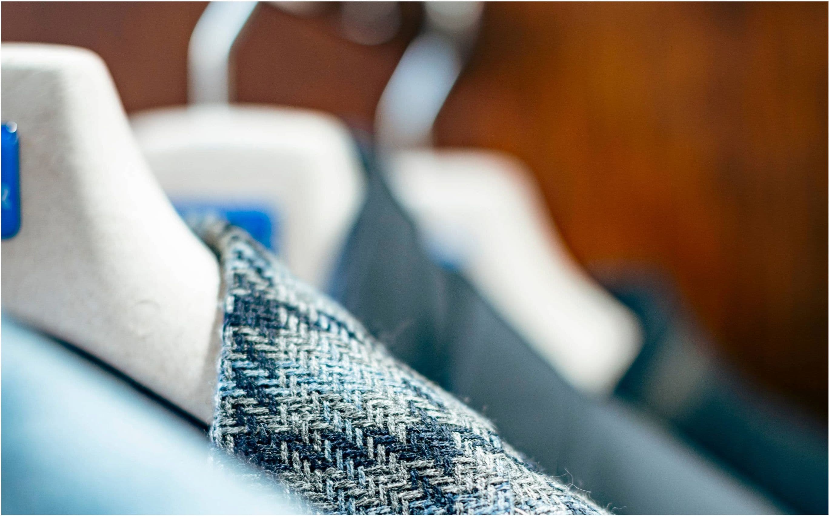 New Arrivals — fresh stock on the rail, close-up of collars in blues with dark wood background.