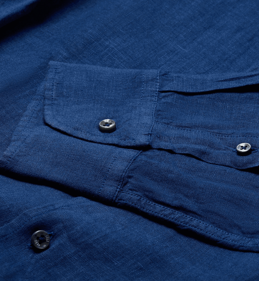 Cuff and button detail of blue linen Fedeli shirt.