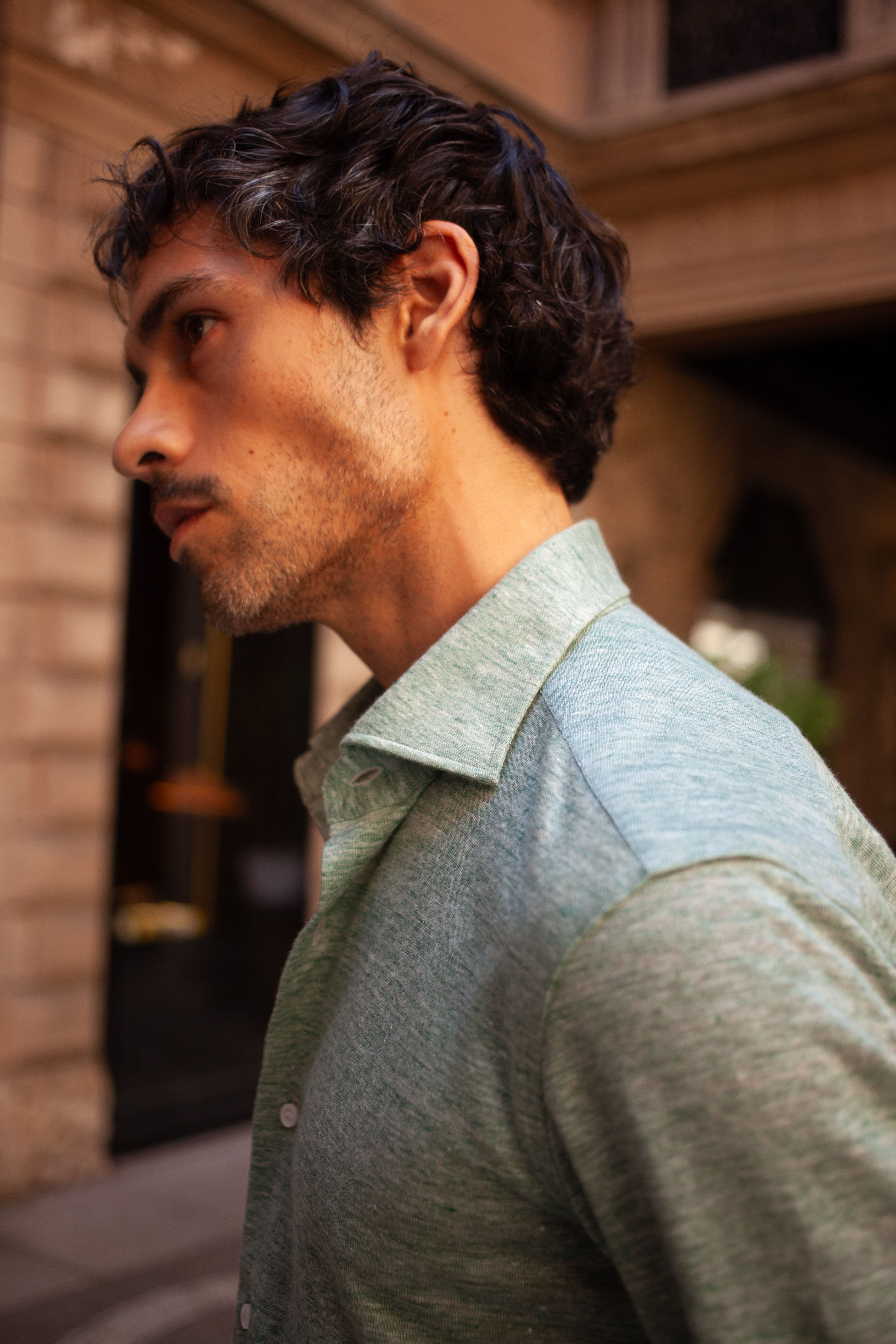 Man wearing green shirt side profile.