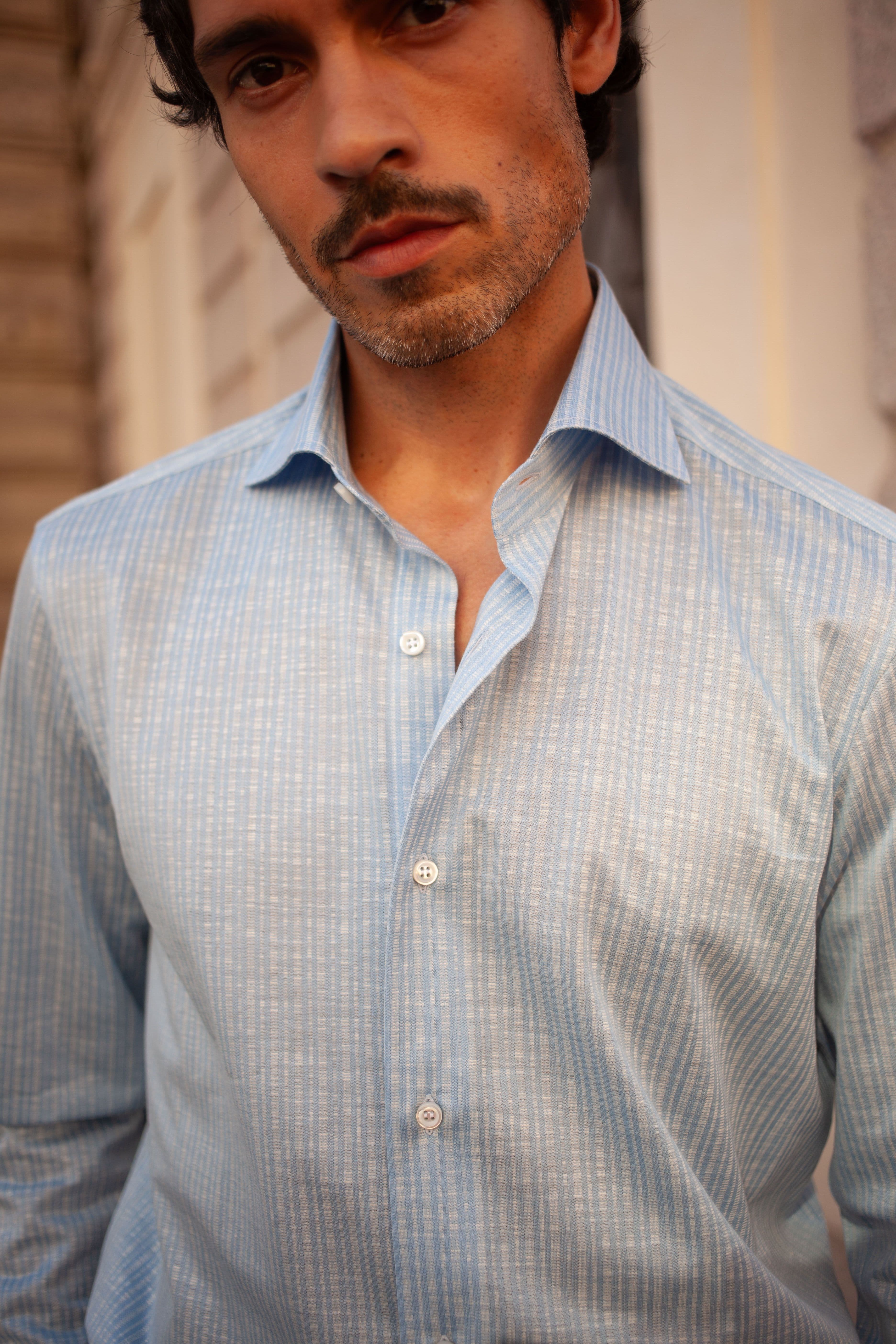 Man wearing blue shirt looking at camera.